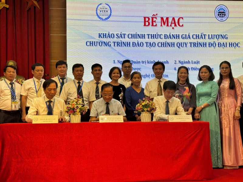 A group of people standing in front of a large screen

Description automatically generated